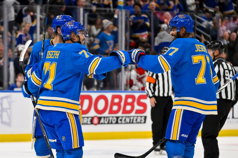 Oct 19, 2024; St. Louis, Missouri, USA;  St. Louis Blues right wing Mathieu Joseph (71) celebrates with defenseman Pierre-Olivier Joseph (77) after scoring against the Carolina Hurricanes during the second period at Enterprise Center. Mandatory Credit: Jeff Curry-Imagn Images