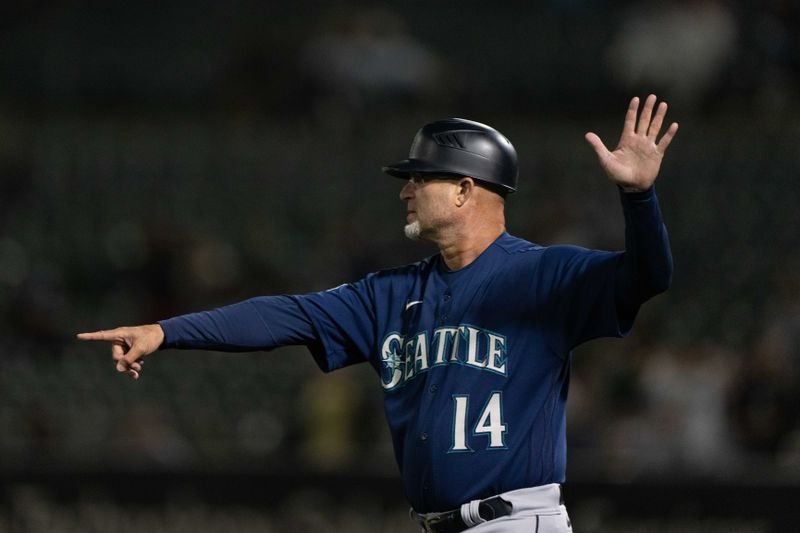 Sep 18, 2023; Oakland, California, USA;  Seattle Mariners third base coach Manny Acta (14) signals during the ninth inning against the Oakland Athletics at Oakland-Alameda County Coliseum. Mandatory Credit: Stan Szeto-USA TODAY Sports