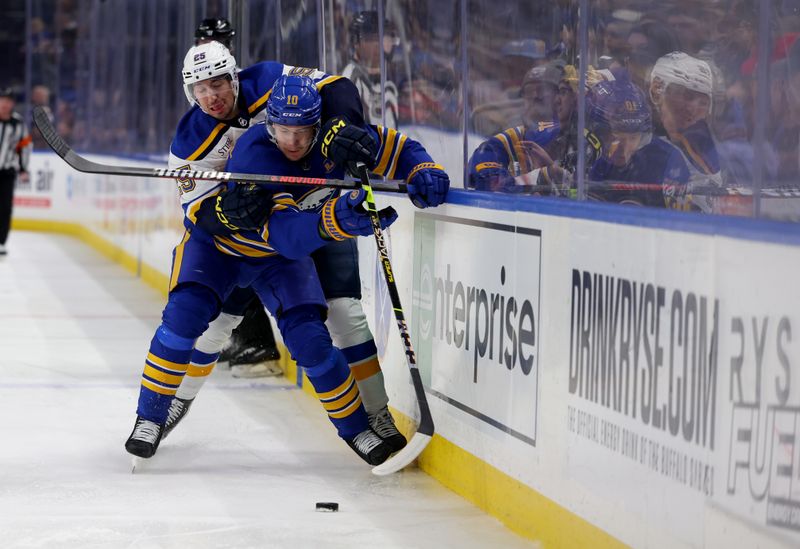 Feb 10, 2024; Buffalo, New York, USA;  St. Louis Blues center Jordan Kyrou (25) and Buffalo Sabres defenseman Henri Jokiharju (10) go after a loose puck during the first period at KeyBank Center. Mandatory Credit: Timothy T. Ludwig-USA TODAY Sports