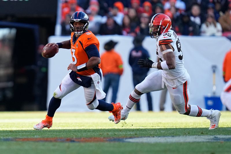 Denver Broncos quarterback Russell Wilson (3) scrambles as Cleveland Browns defensive end Myles Garrett, right, gives chase during the first half of an NFL football game on Sunday, Nov. 26, 2023, in Denver. (AP Photo/Jack Dempsey)