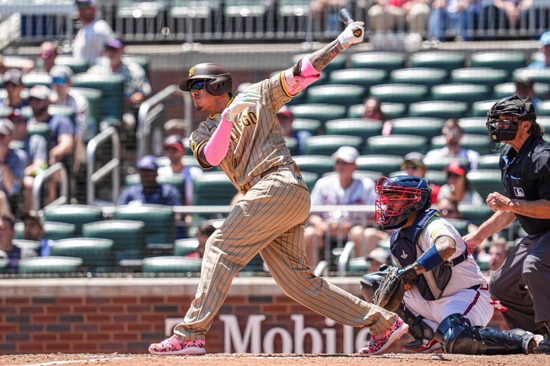 May 20, 2024; Cumberland, Georgia, USA; San Diego Padres third baseman Manny Machado (13) doubles to drive in two runs against the Atlanta Braves during the eighth inning at Truist Park. Mandatory Credit: Dale Zanine-USA TODAY Sports