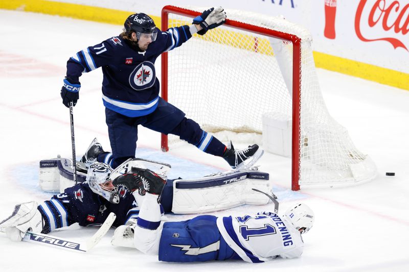 Jan 2, 2024; Winnipeg, Manitoba, CAN; Winnipeg Jets left wing Axel Jonsson-Fjallby (71) attempts to stop a shot by Tampa Bay Lightning center Luke Glendening (11) in the third period at Canada Life Centre. Mandatory Credit: James Carey Lauder-USA TODAY Sports