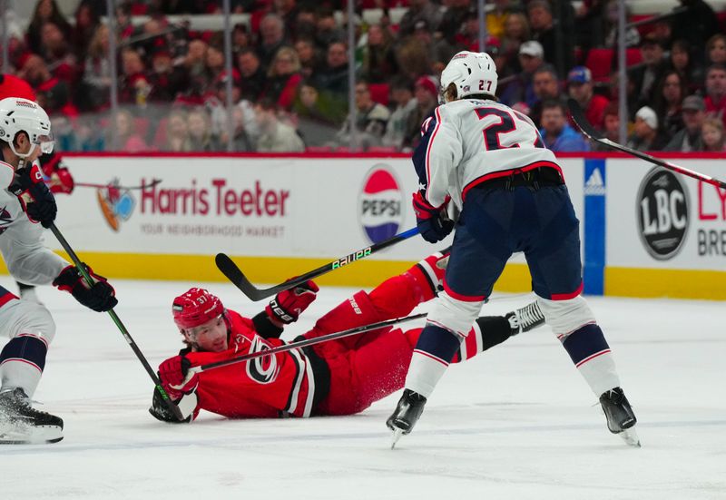 Nov 26, 2023; Raleigh, North Carolina, USA; Columbus Blue Jackets defenseman Adam Boqvist (27) checks Carolina Hurricanes right wing Andrei Svechnikov (37) during the first period at PNC Arena. Mandatory Credit: James Guillory-USA TODAY Sports