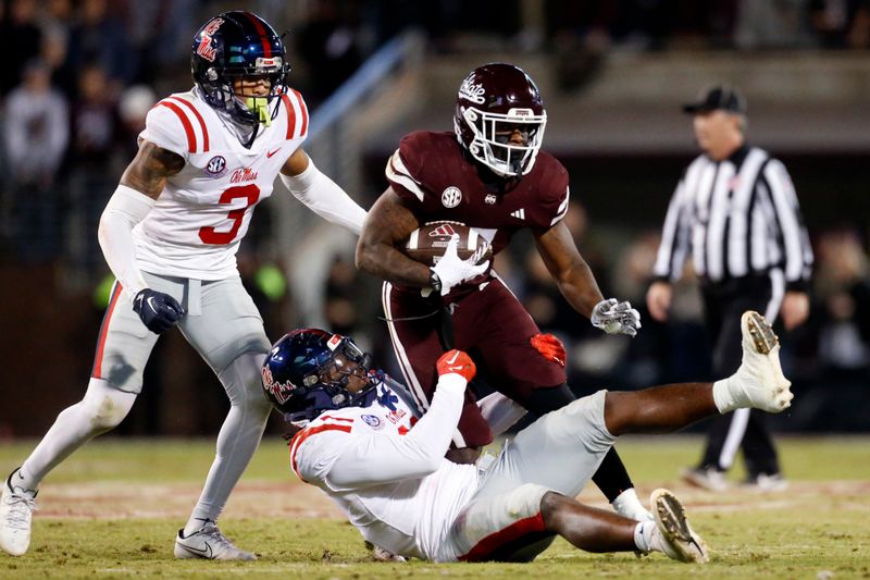 Nov 23, 2023; Starkville, Mississippi, USA; Mississippi State Bulldogs running back Jo'Quavious Marks (7) runs the ball  as Mississippi Rebels defensive back Daijahn Anthony (3) and linebacker Jeremiah Jean-Baptiste (11) make the tackle during the second half  at Davis Wade Stadium at Scott Field. Mandatory Credit: Petre Thomas-USA TODAY Sports