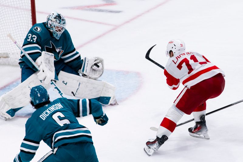 Nov 2, 2025; San Jose, California, USA;  San Jose Sharks goaltender Alex Nedeljkovic (33) blocks a shot by Detroit Red Wings center Dylan Larkin (71) during the third period at SAP Center at San Jose. Mandatory Credit: John Hefti-Imagn Images