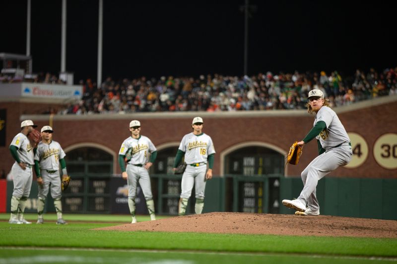 May 16, 2025; San Francisco, California, USA; The Athletics infield watches while relief pitcher Grant Holman (67) warms up during the fifth inning against the San Francisco Giants at Oracle Park. Mandatory Credit: D. Ross Cameron-Imagn Images