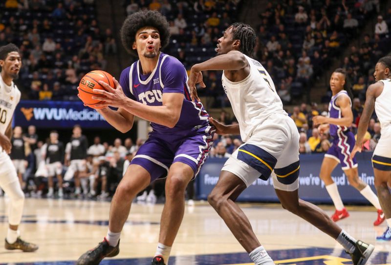 Feb 25, 2025; Morgantown, West Virginia, USA; TCU Horned Frogs forward David Punch (15) drives against West Virginia Mountaineers guard Toby Okani (5) during the second half at WVU Coliseum. Mandatory Credit: Ben Queen-Imagn Images