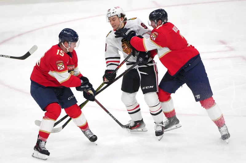 Feb 1, 2025; Sunrise, Florida, USA;  Florida Panthers defenseman Dmitry Kulikov (7) collides with Chicago Blackhawks center Connor Bedard (98) in the third period as center Anton Lundell (15) follows on the play at Amerant Bank Arena. Mandatory Credit: Jim Rassol-Imagn Images