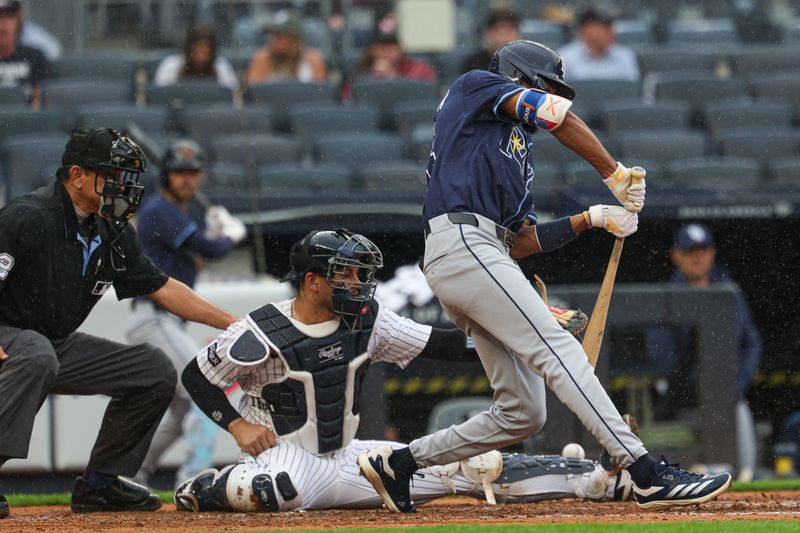 May 4, 2025; Bronx, New York, USA; Tampa Bay Rays center fielder Chandler Simpson (14) is awarded first base on catchers interfernce by New York Yankees catcher J.C. Escarra (25) during the fourth inning at Yankee Stadium. Mandatory Credit: Vincent Carchietta-Imagn Images