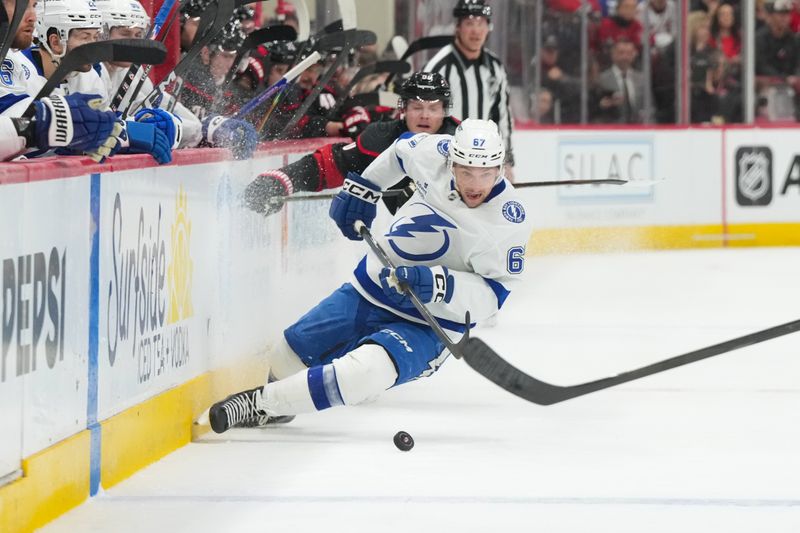 Feb 26, 2026; Raleigh, North Carolina, USA;  Tampa Bay Lightning defenseman Declan Carlile (67) and Carolina Hurricanes right wing Jackson Blake (53) battle over the puck during the second period at Lenovo Center. Mandatory Credit: James Guillory-Imagn Images