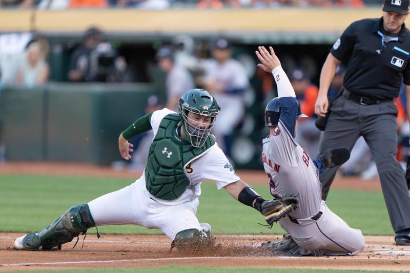 Jul 23, 2024; Oakland, California, USA;  Oakland Athletics catcher Shea Langeliers (23) tags out Houston Astros third base Alex Bregman (2) during the first inning at Oakland-Alameda County Coliseum. Mandatory Credit: Stan Szeto-USA TODAY Sports