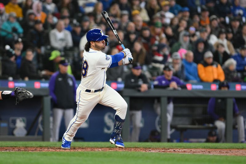 Apr 16, 2023; Seattle, Washington, USA; Seattle Mariners third baseman Eugenio Suarez (28) hits a single against the Colorado Rockies during the fourth inning at T-Mobile Park. Mandatory Credit: Steven Bisig-USA TODAY Sports