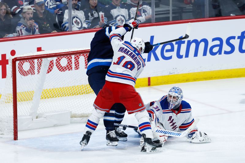 Mar 11, 2025; Winnipeg, Manitoba, CAN;  New York Rangers defenseman Urho Vaakanainen (18) jostles for position with Winnipeg Jets forward Morgan Barron (36) in front of New York Rangers goalie Igor Shesterkin (31) during the third period at Canada Life Centre. Mandatory Credit: Terrence Lee-Imagn Images