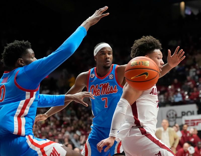 Jan 14, 2025; Tuscaloosa, AL, USA;  Alabama guard Mark Sears (1) drops a pass to a teammate after driving through the lane with Ole Miss forward Malik Dia (0) and Ole Miss guard Davon Barnes (7) defending at Coleman Coliseum. Mandatory Credit: Gary Cosby Jr.-USA TODAY Network via Imagn Images