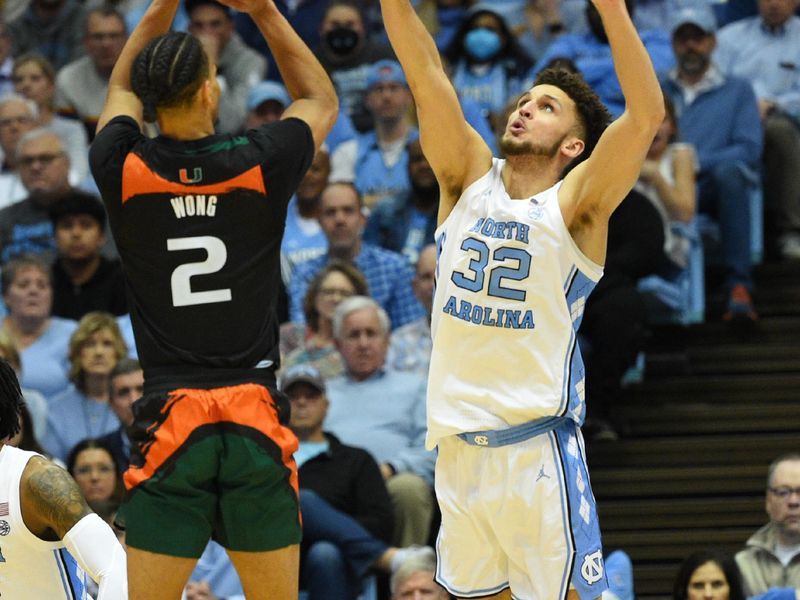 Feb 13, 2023; Chapel Hill, North Carolina, USA; Miami (Fl) Hurricanes guard Isaiah Wong (2) shoots as North Carolina Tar Heels forward Pete Nance (32) defends in the second half at Dean E. Smith Center. Mandatory Credit: Bob Donnan-USA TODAY Sports