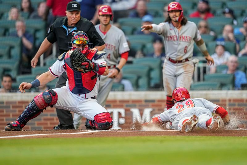 Apr 12, 2023; Cumberland, Georgia, USA; Cincinnati Reds center fielder TJ Friedl (29) dives into home plate behind Atlanta Braves catcher Sean Murphy (12) to score a run during the first inning at Truist Park. Mandatory Credit: Dale Zanine-USA TODAY Sports