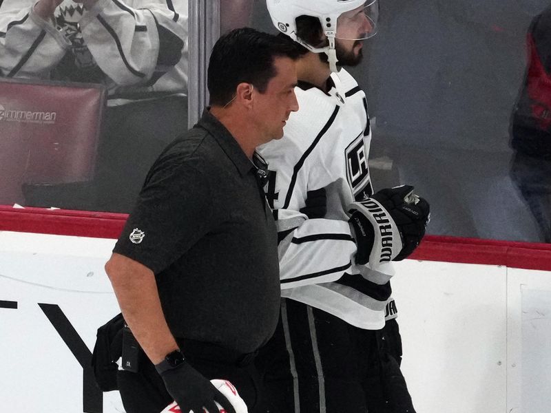 Jan 11, 2024; Sunrise, Florida, USA; Los Angeles Kings center Phillip Danault (24) is helped off the ice after an apparent injury during the first period against the Florida Panthers at Amerant Bank Arena. Mandatory Credit: Jasen Vinlove-USA TODAY Sports