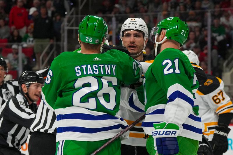 Mar 26, 2023; Raleigh, North Carolina, USA;  aCarolina Hurricanes center Paul Stastny (26) and center Derek Stepan (21) battle against Boston Bruins right wing Garnet Hathaway (21) during the first period t PNC Arena. Mandatory Credit: James Guillory-USA TODAY Sports