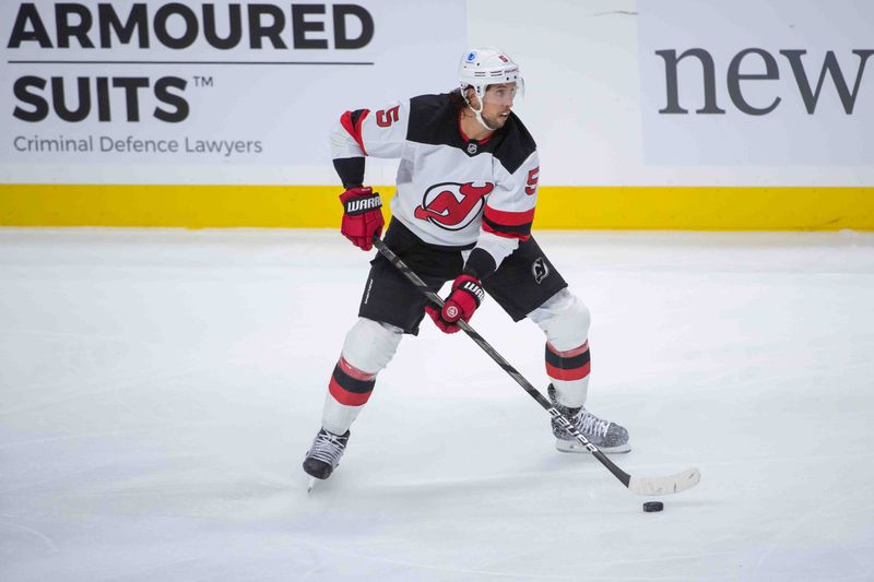 Oct 17, 2024; Ottawa, Ontario, CAN; New Jersey Devils defenseman Brenden Dillon (5) skates with the puck in the third period against the Ottawa Senators at the Canadian Tire Centre. Mandatory Credit: Marc DesRosiers-Imagn Images