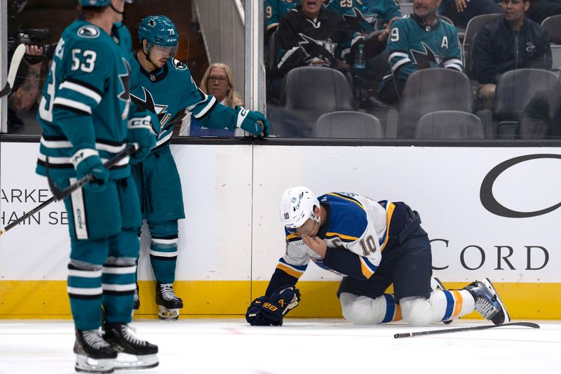 Oct 10, 2024; San Jose, California, USA;  San Jose Sharks left wing Danil Gushchin (75) watches as St. Louis Blues center Brayden Schenn (10) clutches his nose during the third period at SAP Center at San Jose. Mandatory Credit: Stan Szeto-Imagn Images