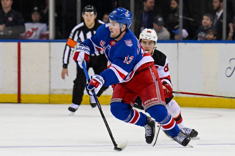 Oct 2, 2025; New York, New York, USA;  New York Rangers left wing Alexis Lafreniere (13) looks to make a pass chased by New Jersey Devils center Jack Hughes (86) during the second period at Madison Square Garden. Mandatory Credit: Dennis Schneidler-Imagn Images