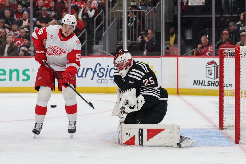 Nov 24, 2025; Newark, New Jersey, USA; Detroit Red Wings center Emmitt Finnie (58) attempts to tip the puck as New Jersey Devils goaltender Jacob Markstrom (25) defends the net during the third period at Prudential Center. Mandatory Credit: Ed Mulholland-Imagn Images