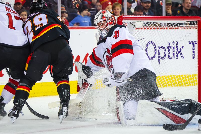 Dec 9, 2023; Calgary, Alberta, CAN; New Jersey Devils goaltender Vitek Vanecek (41) makes a save against Calgary Flames center Dillon Dube (29) during the second period at Scotiabank Saddledome. Mandatory Credit: Sergei Belski-USA TODAY Sports