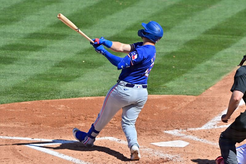 Mar 11, 2024; Tempe, Arizona, USA;  Texas Rangers catcher Andrew Knizner (12) hits an RBI double in the third inning against the Los Angeles Angels during a spring training game at Tempe Diablo Stadium. Mandatory Credit: Matt Kartozian-USA TODAY Sports