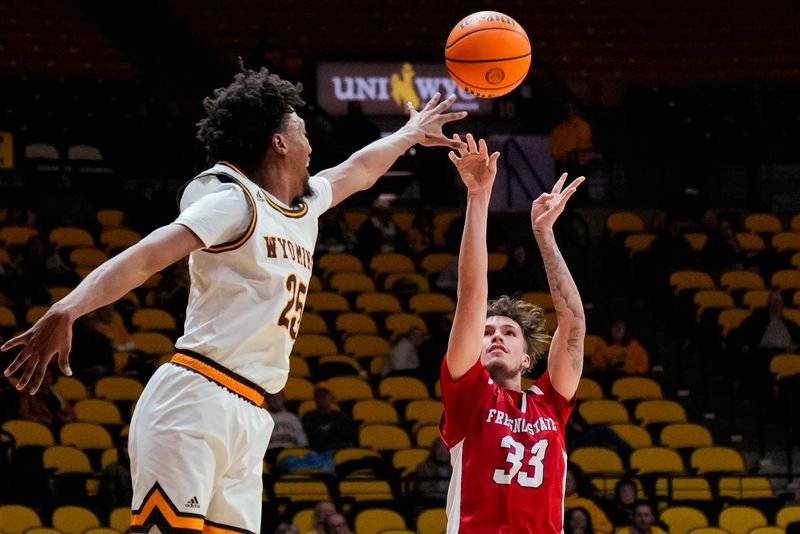 Jan 31, 2023; Laramie, Wyoming, USA; Fresno State Bulldogs guard Steven Vasquez (33) gets a shot away against Wyoming Cowboys forward Jeremiah Oden (25) during the second half at Arena-Auditorium. Mandatory Credit: Troy Babbitt-USA TODAY Sports