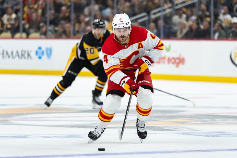 Oct 14, 2023; Pittsburgh, Pennsylvania, USA; Calgary Flames defenseman Rasmus Andersson (4) skates the puck down ice against the Pittsburgh Penguins during the second period at PPG Paints Arena. Mandatory Credit: Scott Galvin-USA TODAY Sports