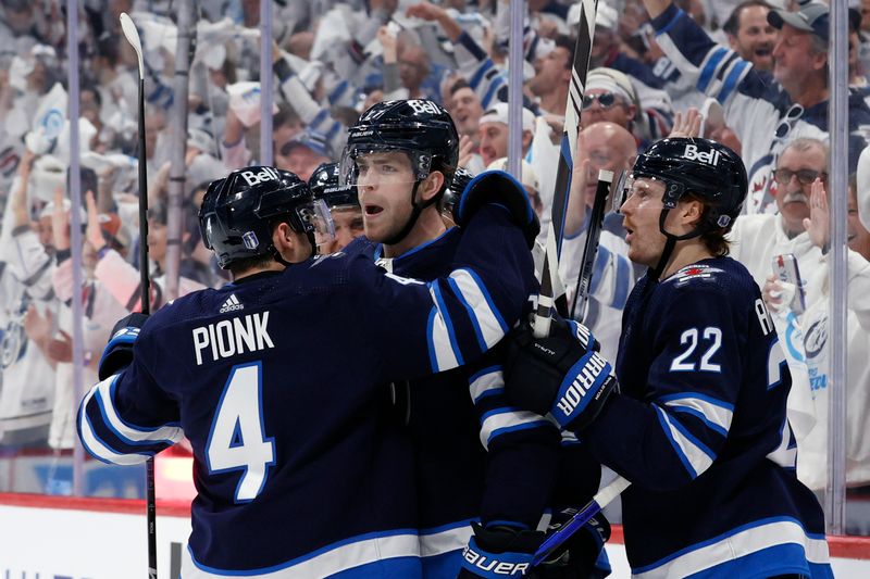 Apr 21, 2024; Winnipeg, Manitoba, CAN; Winnipeg Jets center Adam Lowry (17) celebrates his second period goal with Winnipeg Jets defenseman Neal Pionk (4) and Winnipeg Jets center Mason Appleton (22) against the Colorado Avalanche in game one of the first round of the 2024 Stanley Cup Playoffs at Canada Life Centre. Mandatory Credit: James Carey Lauder-USA TODAY Sports