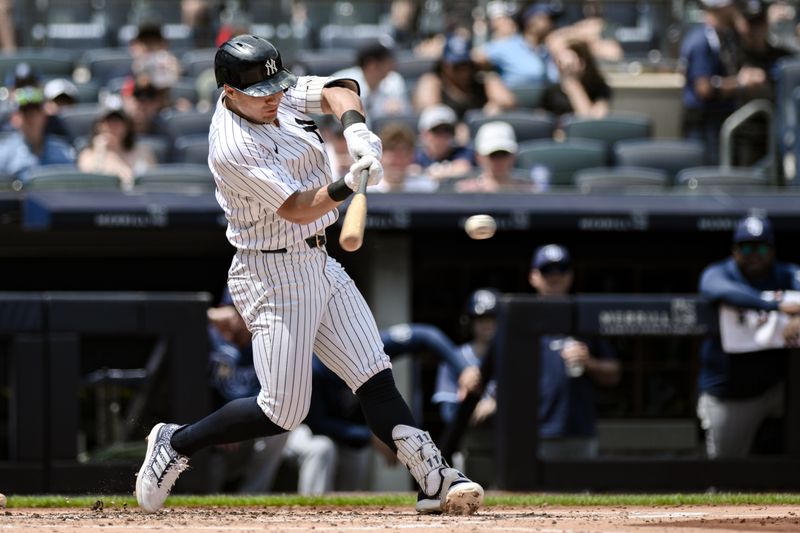 Jul 21, 2024; Bronx, New York, USA; New York Yankees shortstop Anthony Volpe (11) hits a single against the Tampa Bay Rays during the second inning at Yankee Stadium. Mandatory Credit: John Jones-USA TODAY Sports