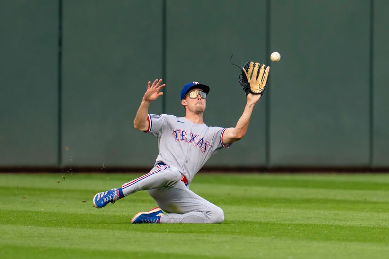 Jun 10, 2025; Minneapolis, Minnesota, USA; Texas Rangers center fielder Evan Carter (32) dives and catches a fly ball against the Minnesota Twins in the first inning at Target Field. Mandatory Credit: Jesse Johnson-Imagn Images