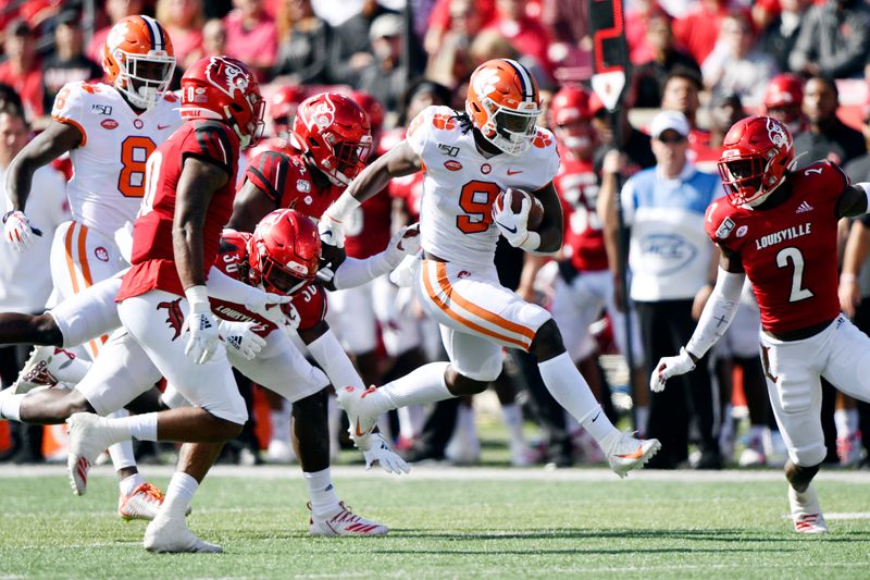 Oct 19, 2019; Louisville, KY, USA; Clemson Tigers running back Travis Etienne (9) runs the ball against the Louisville Cardinals during the first quarter of play at Cardinal Stadium. Mandatory Credit: Jamie Rhodes-USA TODAY Sports