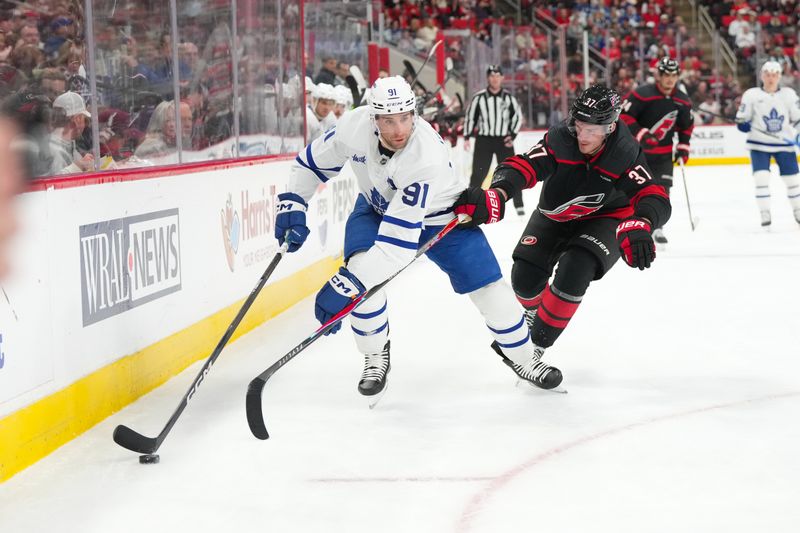 Dec 4, 2025; Raleigh, North Carolina, USA; aToronto Maple Leafs center John Tavares (91) skates with the puck past Carolina Hurricanes right wing Andrei Svechnikov (37) during the second period t Lenovo Center. Mandatory Credit: James Guillory-Imagn Images