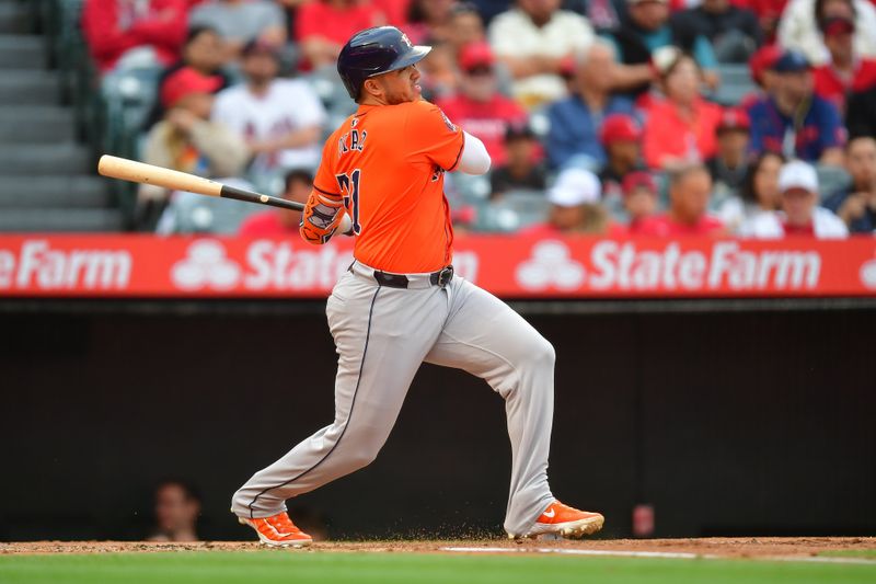 Jun 7, 2024; Anaheim, California, USA; Houston Astros catcher Yainer Diaz (21) hits an RBI single against the Los Angeles Angels during the first inning at Angel Stadium. Mandatory Credit: Gary A. Vasquez-USA TODAY Sports