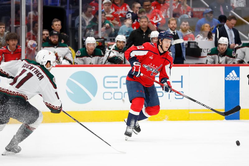 Mar 3, 2024; Washington, District of Columbia, USA; Washington Capitals center Michael Sgarbossa (23) passes the puck as Arizona Coyotes right wing Dylan Guenther (11) defends in the first period at Capital One Arena. Mandatory Credit: Geoff Burke-USA TODAY Sports
