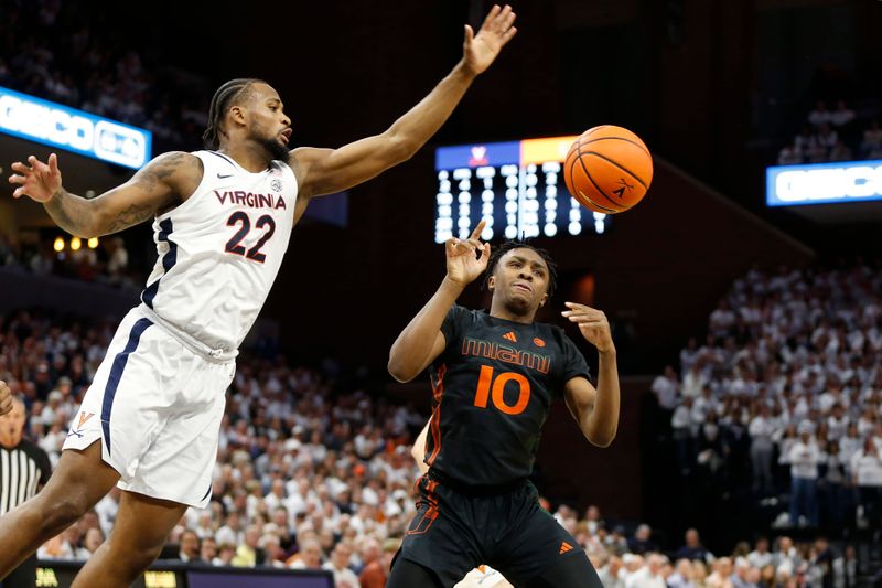 Feb 5, 2024; Charlottesville, Virginia, USA; Virginia Cavaliers forward Jordan Minor (22) knocks the ball away from Miami (Fl) Hurricanes guard Paul Djobet (10) during the first half at John Paul Jones Arena. Mandatory Credit: Amber Searls-USA TODAY Sports