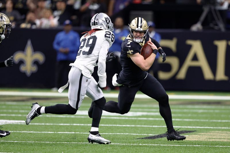 New Orleans Saints tight end Taysom Hill (7) runs against Las Vegas Raiders cornerback Anthony Averett (29) during the second half of an NFL football game Sunday, Oct. 30, 2022, in New Orleans. (AP Photo/Butch Dill)