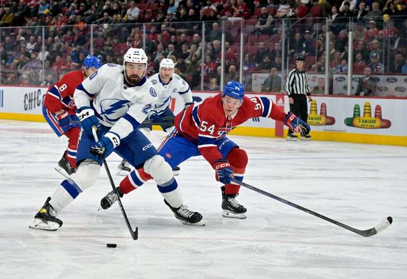 Nov 7, 2023; Montreal, Quebec, CAN; Tampa Bay Lightning forward Nicholas Paul (20) plays the puck and Montreal Canadiens defenseman Jordan Harris (54) defends during the second period at the Bell Centre. Mandatory Credit: Eric Bolte-USA TODAY Sports