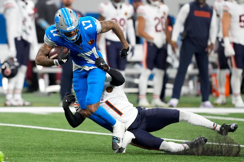 Detroit Lions wide receiver Tim Patrick (17) runs after a catch as Chicago Bears cornerback Jaylon Johnson (1) makes the tackle during the first half of an NFL football game, Sunday, Nov. 17, 2024, in Detroit. (AP Photo/Carlos Osorio)