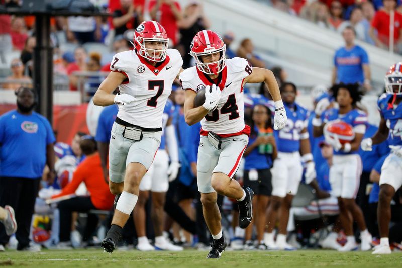 Oct 28, 2023; Jacksonville, Florida, USA; Georgia Bulldogs wide receiver Ladd McConkey (84) runs for a first down with help from tight end Lawson Luckie (7) in the second half at EverBank Stadium. Mandatory Credit: Jeff Swinger-USA TODAY Sports