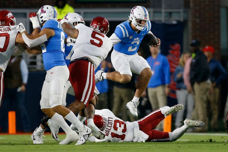 Oct 7, 2023; Oxford, Mississippi, USA; Mississippi Rebels quarterback Jaxson Dart (2) hurdles over Arkansas Razorbacks defensive back Alfahiym Walcott (13) during the first quarter at Vaught-Hemingway Stadium. Mandatory Credit: Petre Thomas-USA TODAY Sports