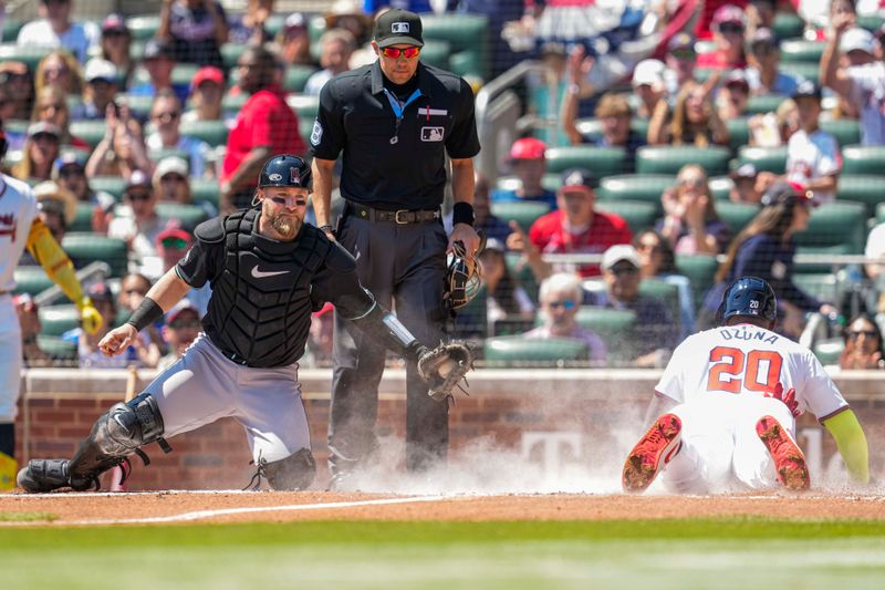 Apr 7, 2024; Cumberland, Georgia, USA; Atlanta Braves designated hitter Marcell Ozuna (20) scores a run behind Arizona Diamondbacks catcher Tucker Barnhart (16) during the second inning at Truist Park. Mandatory Credit: Dale Zanine-USA TODAY Sports