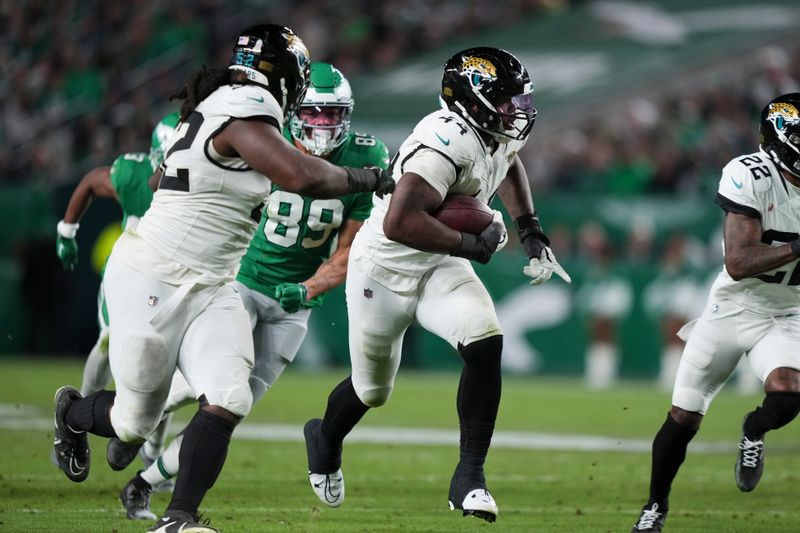 Jacksonville Jaguars defensive end Travon Walker (44) runs with the ball after recovering a fumble for a touchdown during the second half of an NFL football game against the Philadelphia Eagles on Sunday, Nov. 3, 2024, in Philadelphia.(AP Photo/Matt Slocum)