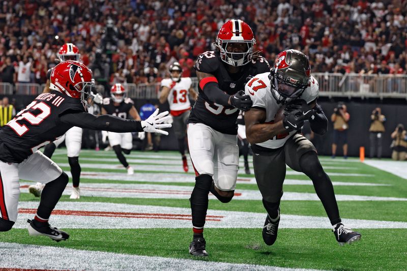 Tampa Bay Buccaneers wide receiver Sterling Shepard (17) pulls in a touchdown pass between Atlanta Falcons cornerback Clark Phillips III (22) and cornerback Antonio Hamilton Sr. (33) during the first half of an NFL football game Thursday, Oct. 3, 2024, in Atlanta. (AP Photo/Butch Dill)