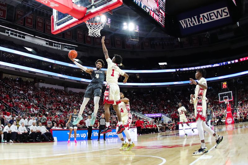 Feb 4, 2023; Raleigh, North Carolina, USA; Georgia Tech Yellow Jackets forward Javon Franklin (4) goes to dunk defended North Carolina State Wolfpack guard Jarkel Joiner (1) during the second half of the game at PNC Arena. Mandatory Credit: Jaylynn Nash-USA TODAY Sports