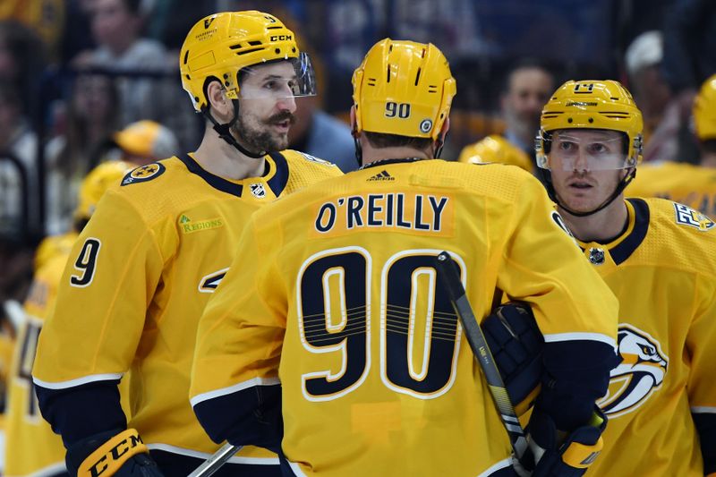Mar 5, 2024; Nashville, Tennessee, USA; Nashville Predators center Ryan O'Reilly (90) talks with left wing Filip Forsberg (9) and center Gustav Nyquist (14) during the first period against the Montreal Canadiens at Bridgestone Arena. Mandatory Credit: Christopher Hanewinckel-USA TODAY Sports