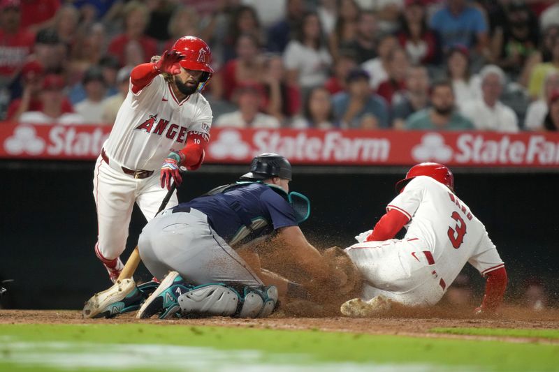 Aug 31, 2024; Anaheim, California, USA; Los Angeles Angels left fielder Taylor Ward (3) is tagged out at home plate by Seattle Mariners catcher Cal Raleigh (29) on a bunt attempt by Angels shortstop Jack Lopez (10) in the eighth inning at Angel Stadium. Mandatory Credit: Kirby Lee-USA TODAY Sports