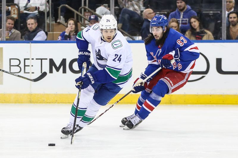 Jan 8, 2024; New York, New York, USA;  Vancouver Canucks center Pius Suter (24) and New York Rangers center Mika Zibanejad (93) chases the puck in the second period at Madison Square Garden. Mandatory Credit: Wendell Cruz-USA TODAY Sports